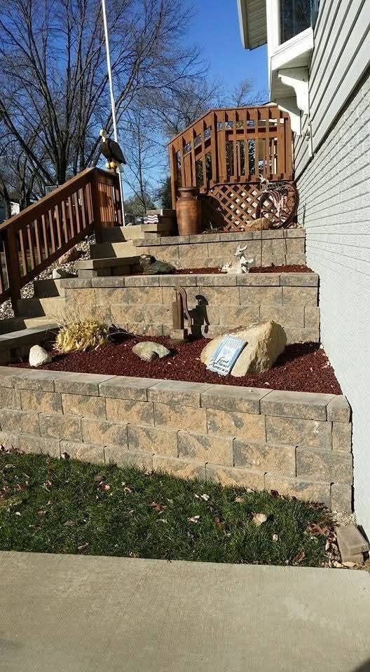 Tiered block retaining wall with red mulch bed — deck and decorative landscaping