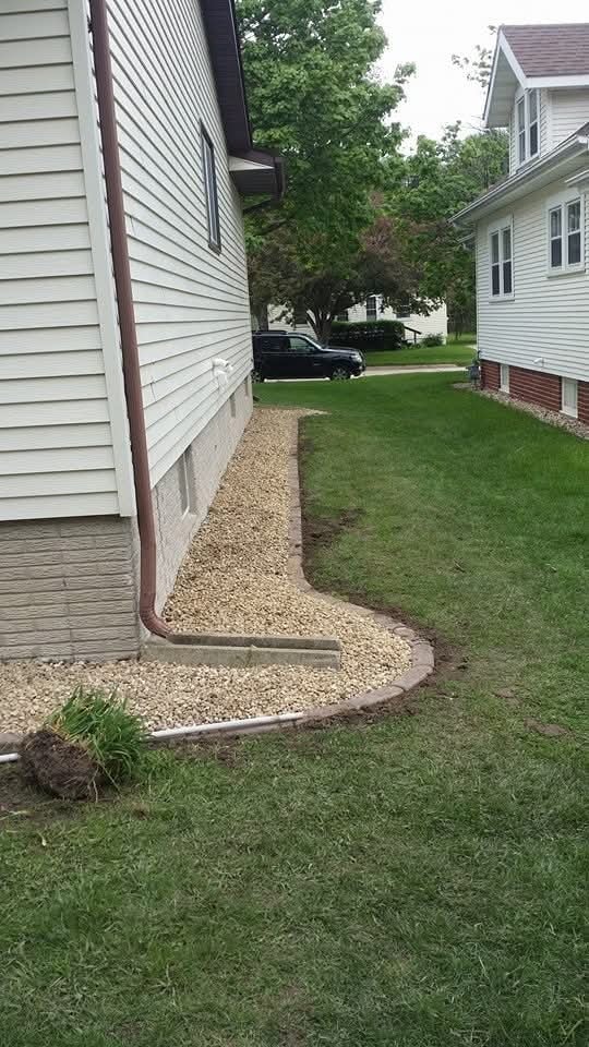 Foundation gravel bed with brick edging — side of home, downspout drainage