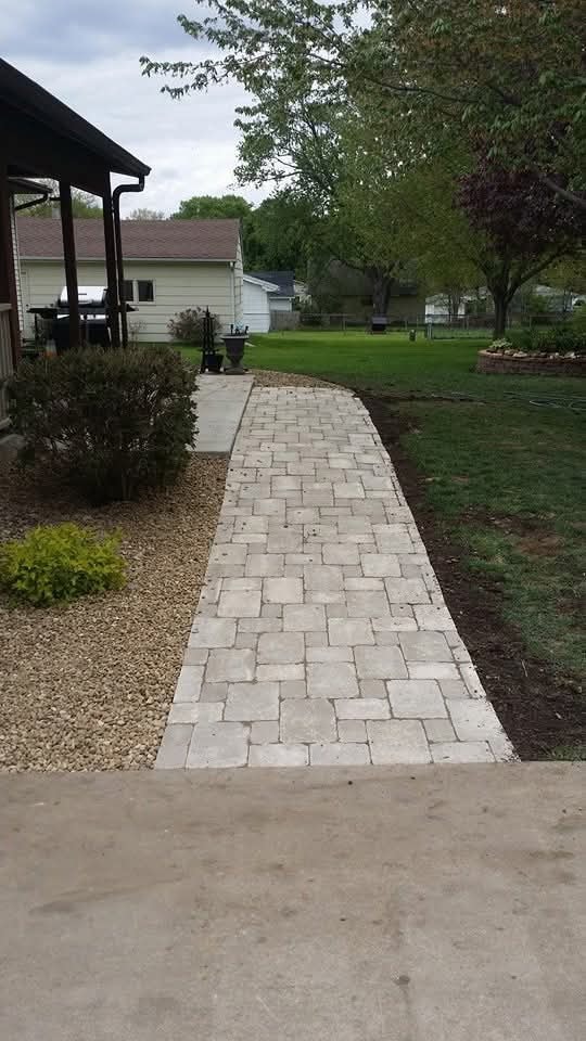 Completed paver walkway — light stone pattern leading to backyard