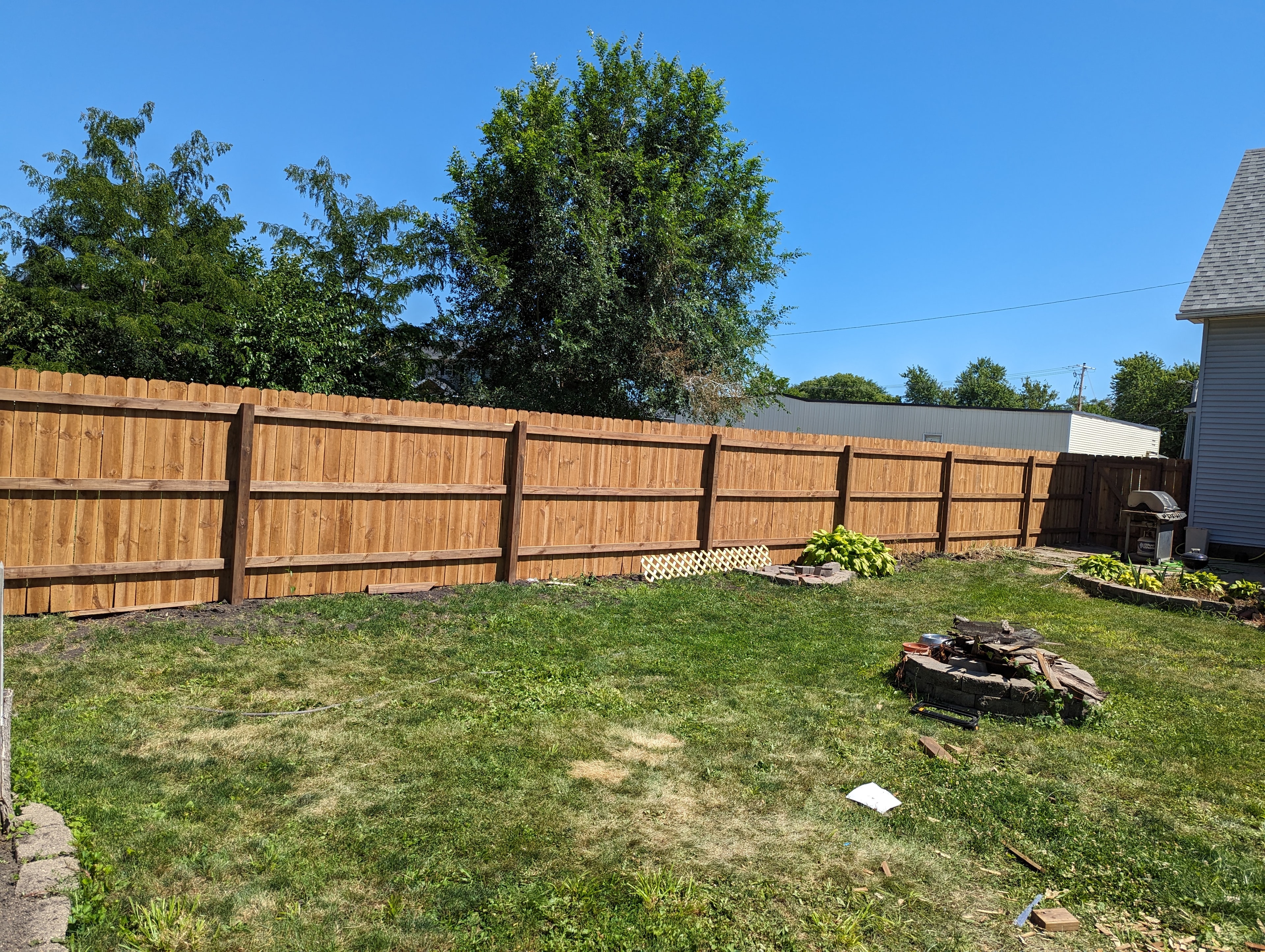 Full backyard fence line with fire pit