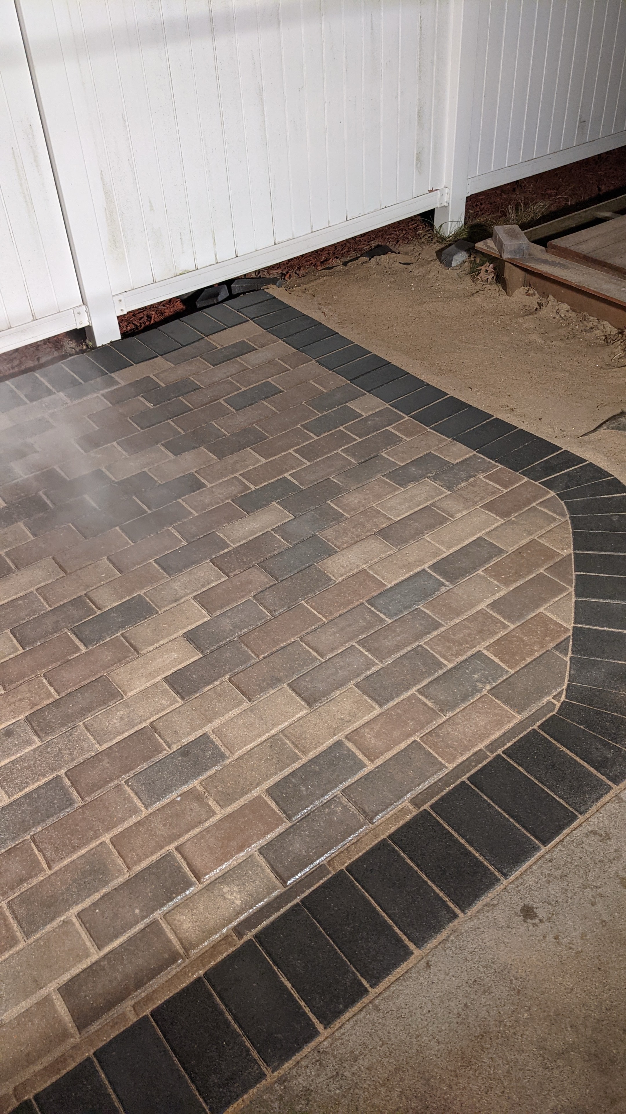 Paver patio installation — two-tone brick pattern