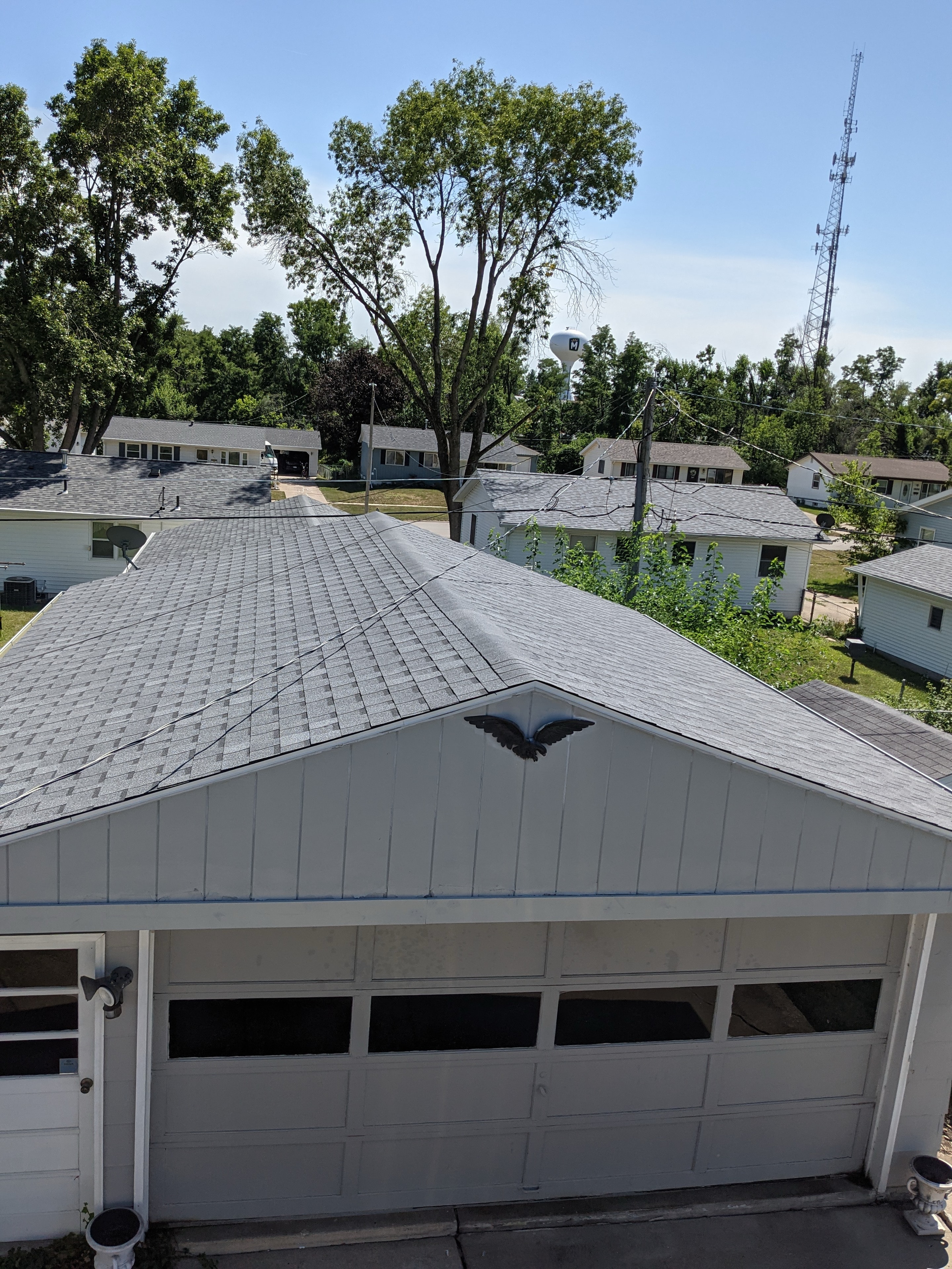 Completed garage roof — gray shingles with eagle detail