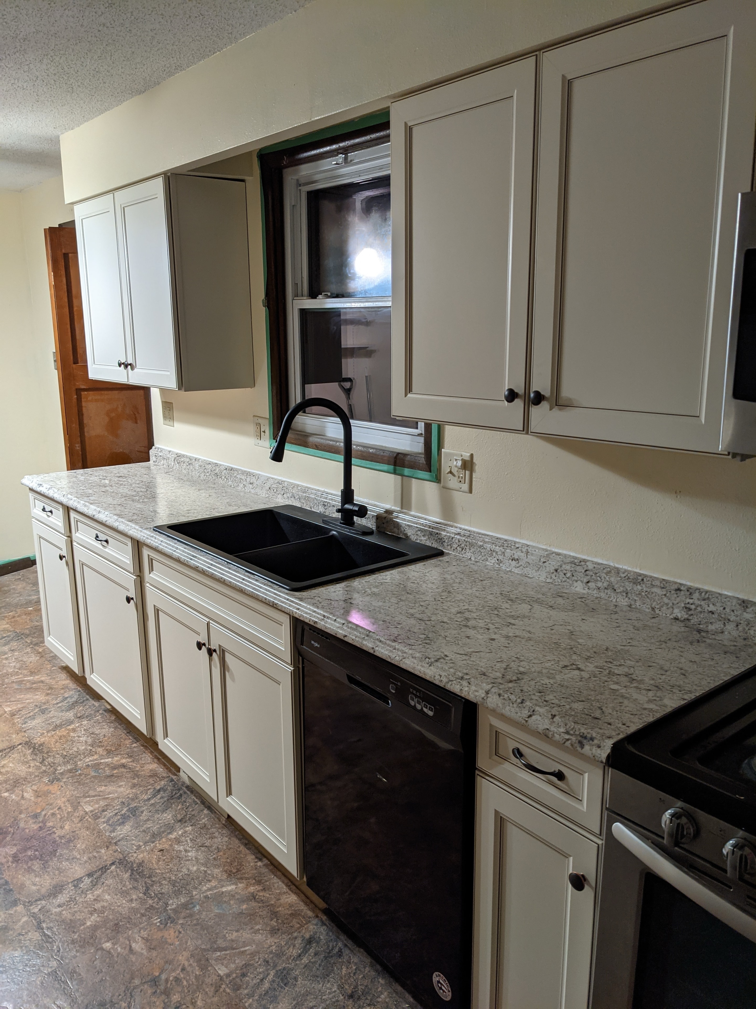 Kitchen remodel — new white cabinets, granite countertops, black fixtures
