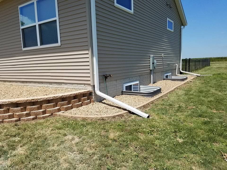 Retaining wall with gravel bed and egress window well
