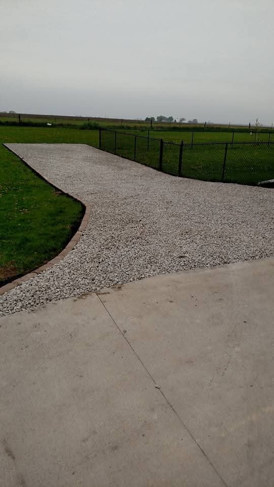 Gravel driveway with concrete apron and chain-link fencing — rural property