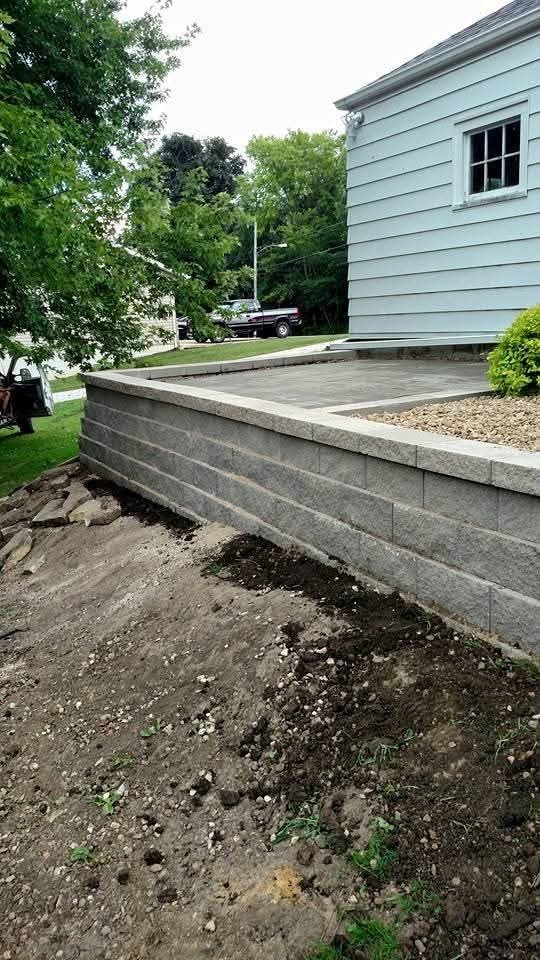 Block retaining wall and stamped concrete patio — light blue home, in progress