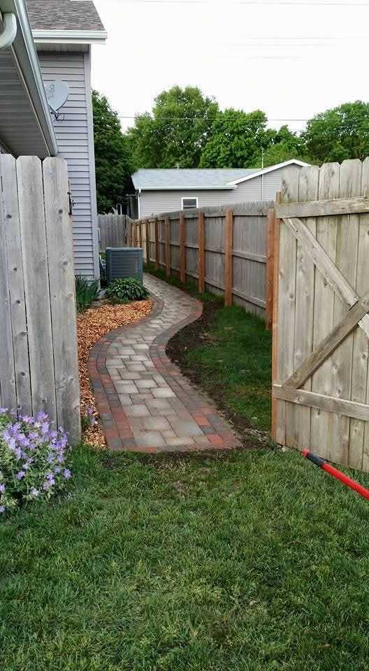 Curved brick paver walkway with wood fence and gate — backyard side passage